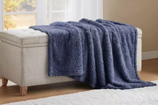 a blue throw blanket on an ottoman