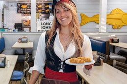 a woman dressed like a pirate holding a plate of food in long john silvers