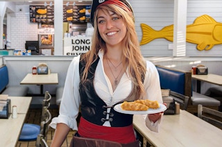 a woman dressed like a pirate holding a plate of food in long john silvers