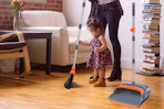 a woman and child using a broom