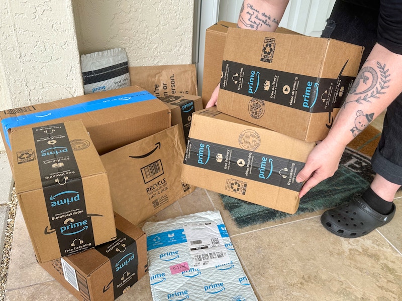 Someone picking up Amazon prime boxes on the porch
