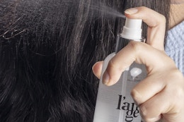 a woman spraying l'ange heat protectant