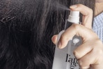 a woman spraying l'ange heat protectant
