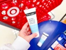 hand holding a neutrogena daily face moisturizer in front of target cart