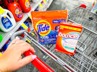 hand pushing a cart with tide and bounce laundry products
