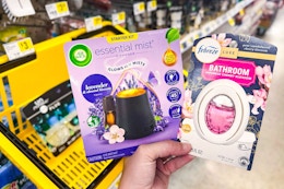 hand holding air wick and febreze products