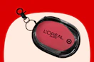 Black oval keychain pouch with pink center showing L'Oréal Paris logo and Target bullseye, on a red and cream background.