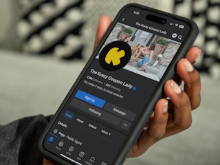 Someone holding a phone displaying the KCL Facebook page