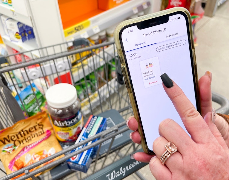 Someone tapping a coupon in the Walgreens app