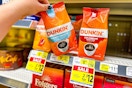 hand picking up a bag of dunkin' coffee