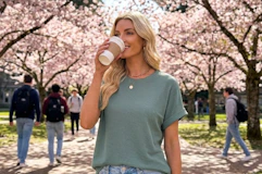 a woman wearing a shirt and jeans in a quad