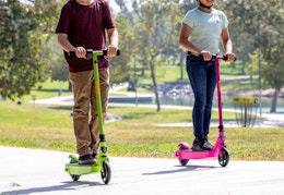 children riding on a green or pink Razor electric scooter