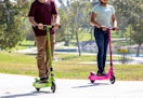 children riding on a green or pink Razor electric scooter