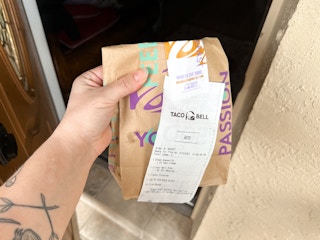 Someone bringing a bag of Taco Bell into their house