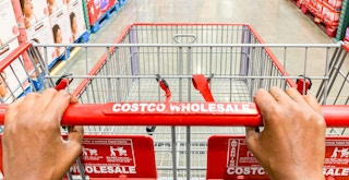 A Costco shopping cart being pushed down an aisle