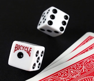 Two dice and cards on a black background