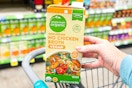 hand holding a carton of simple truth chicken broth