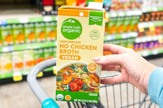 hand holding a carton of simple truth chicken broth