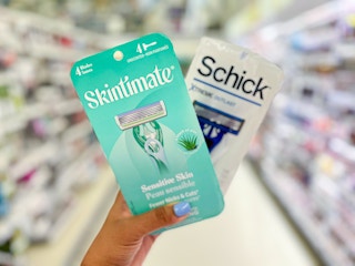 hand holding a pack of Skintimate disposable razors and Schick disposable razors