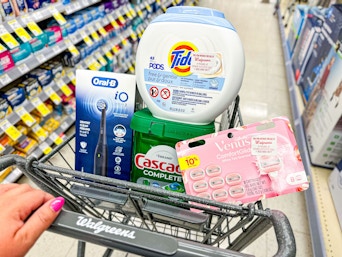 hand pushing a walgreens shoping cart with P&G products