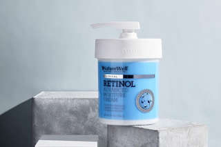 A large bottle of retinol cream on a stone