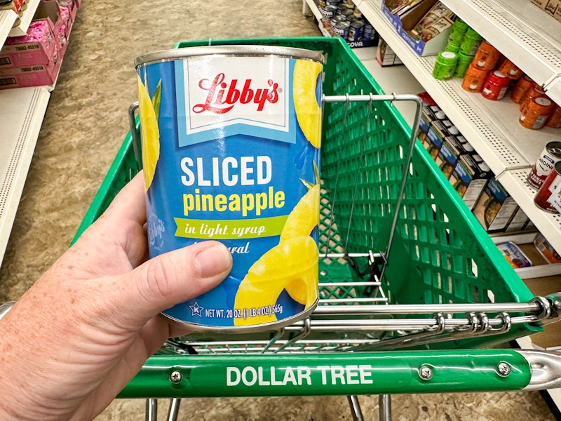 a can of sliced pineapple next to a dollar tree cart