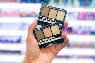 hand holding up two covergirl eyeshadow kits