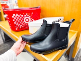 Women's boots is shoe aisle at Target with shopping basket in the background