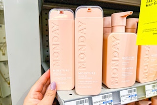 hand grabbing monday haircare bottle on a shelf