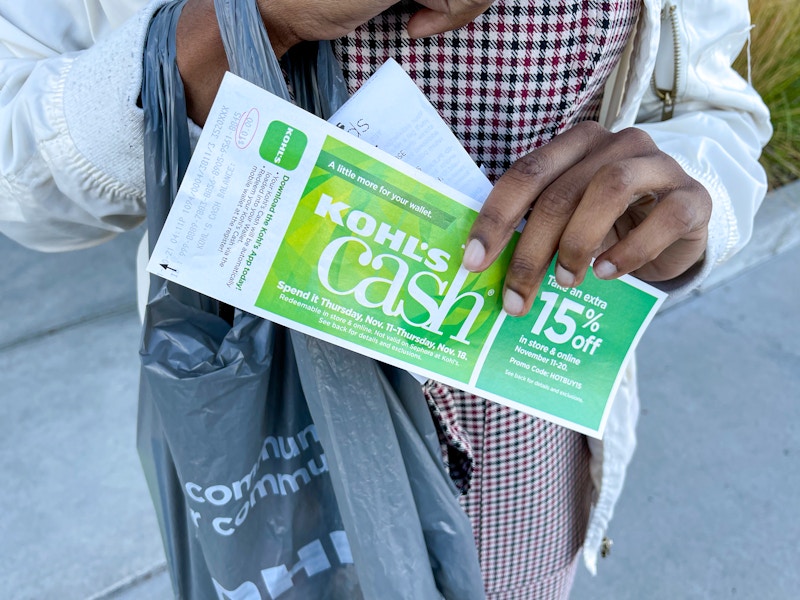 A person holding Kohl's cash and a receipt