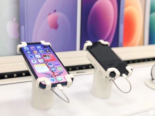 two iphones on display in front of Apple wall at Target