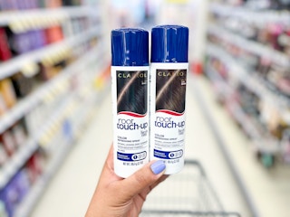 hand holding two cans of clairol hair color