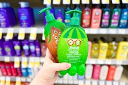 person holding 2 raw sugar kids shampoos