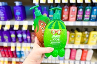 person holding 2 raw sugar kids shampoos