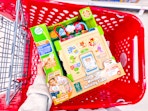 hand holding a leapfrog activity cube over a target cart