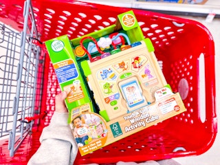 hand holding a leapfrog activity cube over a target cart