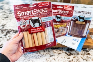 a hand holding a bag of dog treats