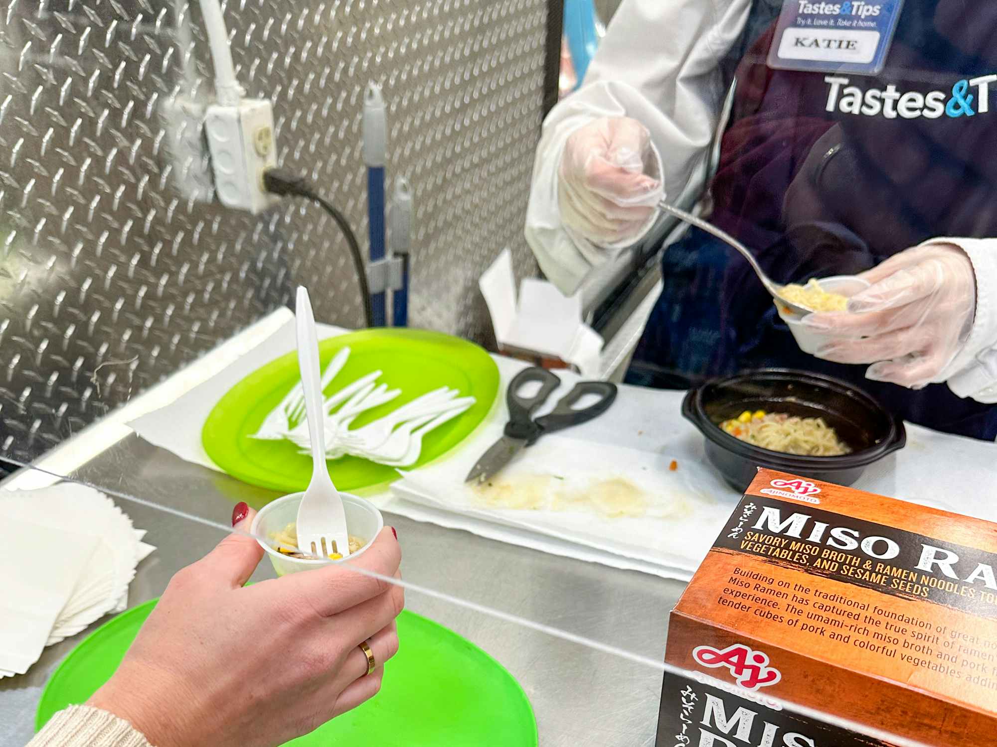 someone taking a free sample from a Tastes & Tips booth at Sam's Club