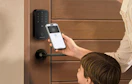 a person using a phone to unlock a front door