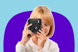 child holding a black instant camera