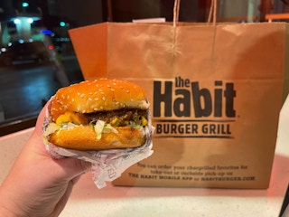 a charburger from the habit in front of a paper bag