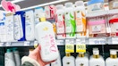 person holding dove serum body wash near other dove body washes with clearance signs for 50% off