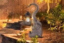ILLUMINEW Solar Outdoor Garden Decor Elephant Statues Light sitting in a garden at dusk.