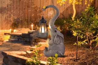 ILLUMINEW Solar Outdoor Garden Decor Elephant Statues Light sitting in a garden at dusk.