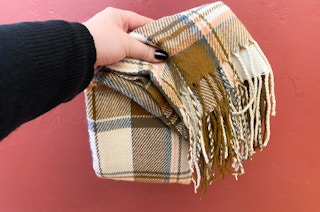 hand holding a scarf on a red background