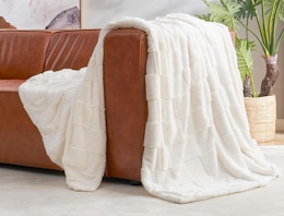 a ivory faux fur throw in a couch 