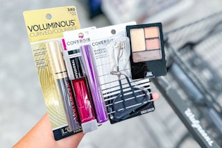 hand holding cosmetics next to a walgreens shopping cart