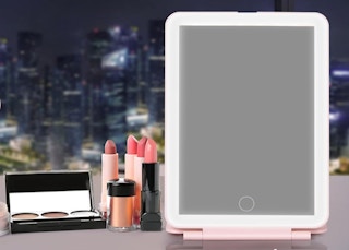 a LED mirror on a table with makeup