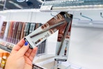 hand grabbing l'oreal kohl eyeliner from a store display