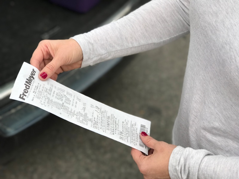 A person holding a Fred Meyer receipt.